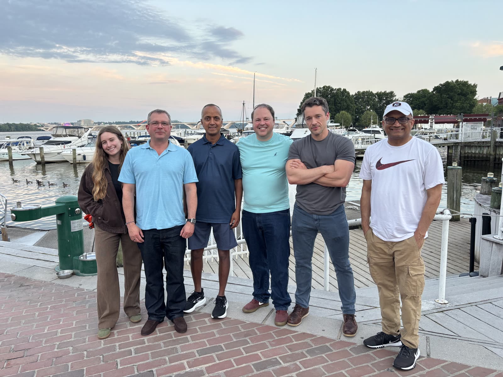 Plainsight team on a waterfront boardwalk at sunset